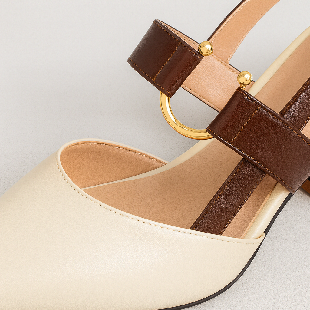 Chic slingback block-heel shoe featuring a pointed toe, dual-tone design, and gold buckle accent.